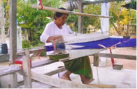 Sula's mother Pin hand weaving Thai silk with a traditional loom at her home